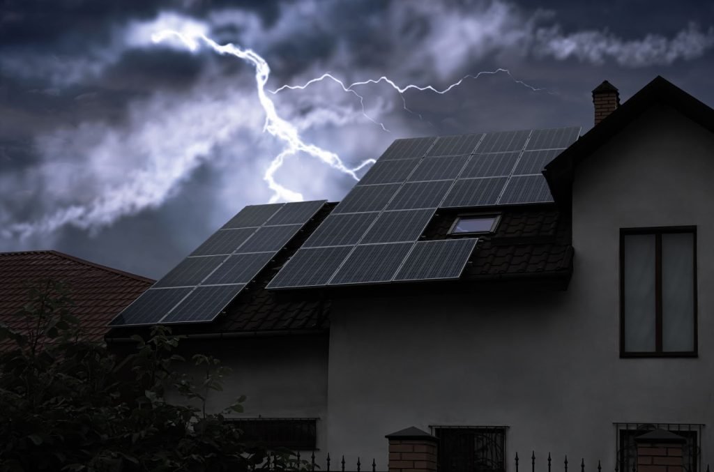 Home with solar panels during a power outage at night with lights still on